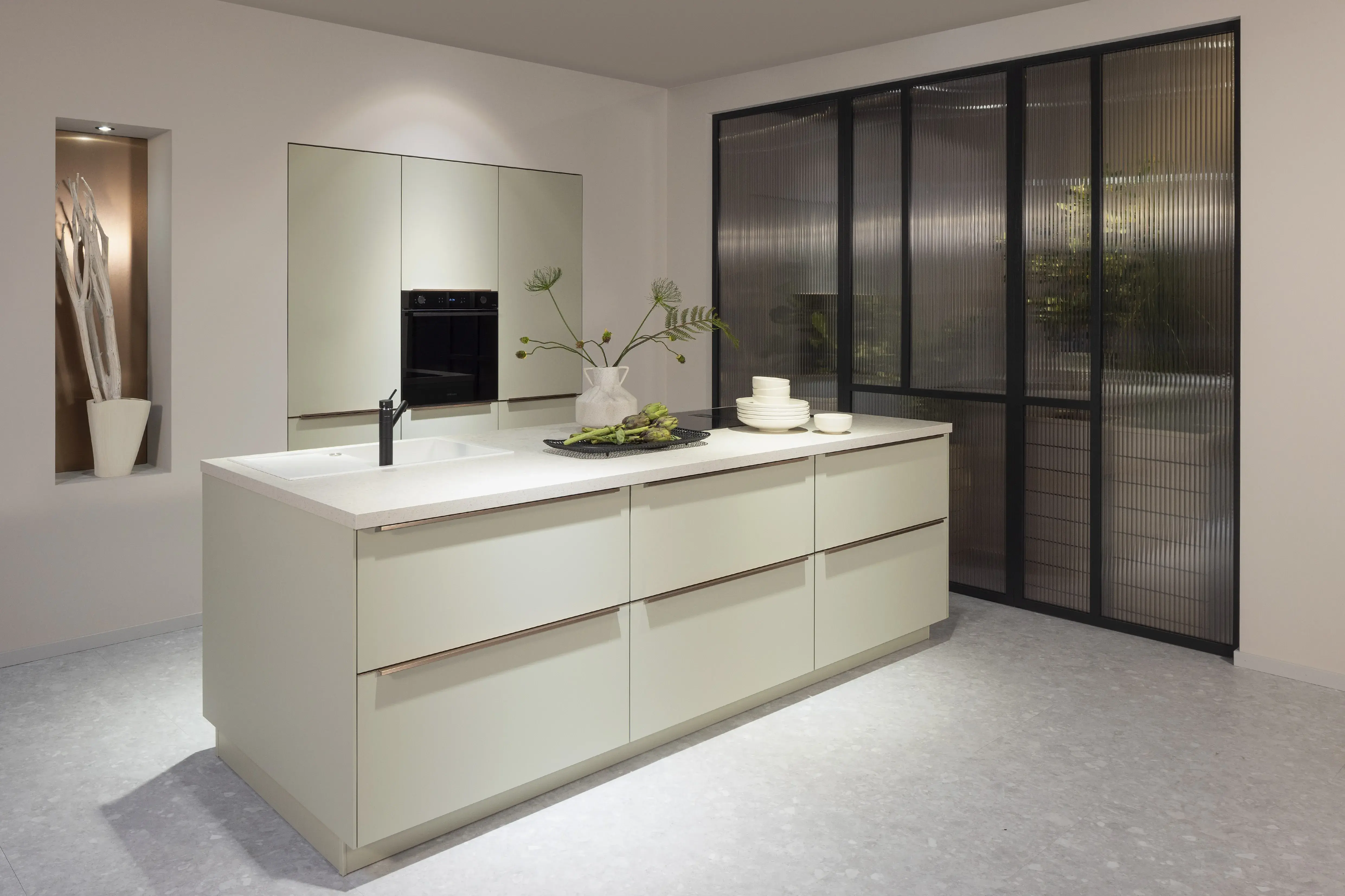 APL: 322 Terrazzo Weiß Korpus: 194 Schiefergrau Front: 494 Lack, Jade Premium matt Griff: Griffleiste Bronze metallic Geräte: Samsung  Armatur: Nobilia Spüle: Elleci  Features: Bronze + Jade, eingekoffertes Element, Handtuchhalter unter Spüle, neuer Schubkasten, moderne Insellösung, symmetrische Küche, Griffleiste in Bronze metallic